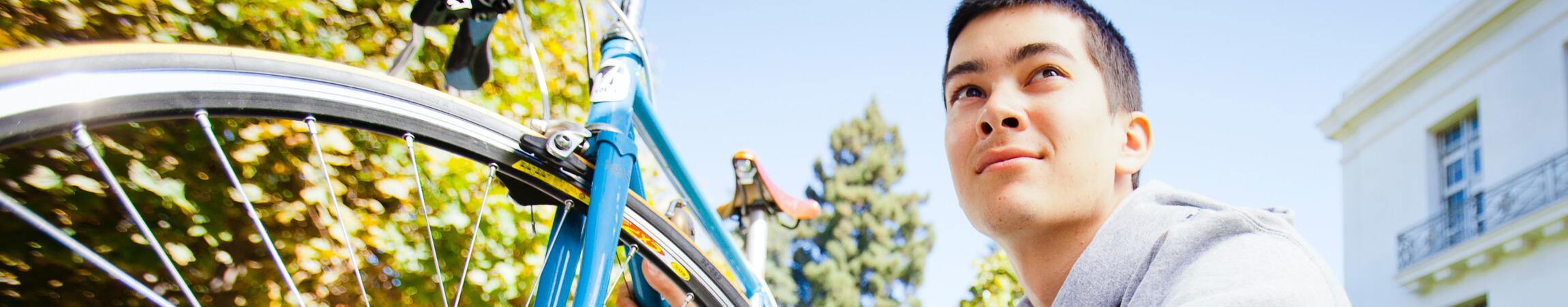 Man looking into the distance sitting besides a bicycle